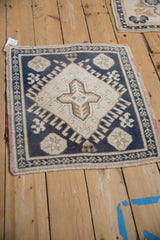 Distressed Oushak rug corner, navy, ivory, and blush geometric motifs with wear.