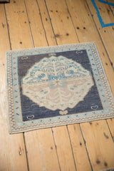 Vintage Oushak mat with a central medallion on a navy field, shown from a high angle.
