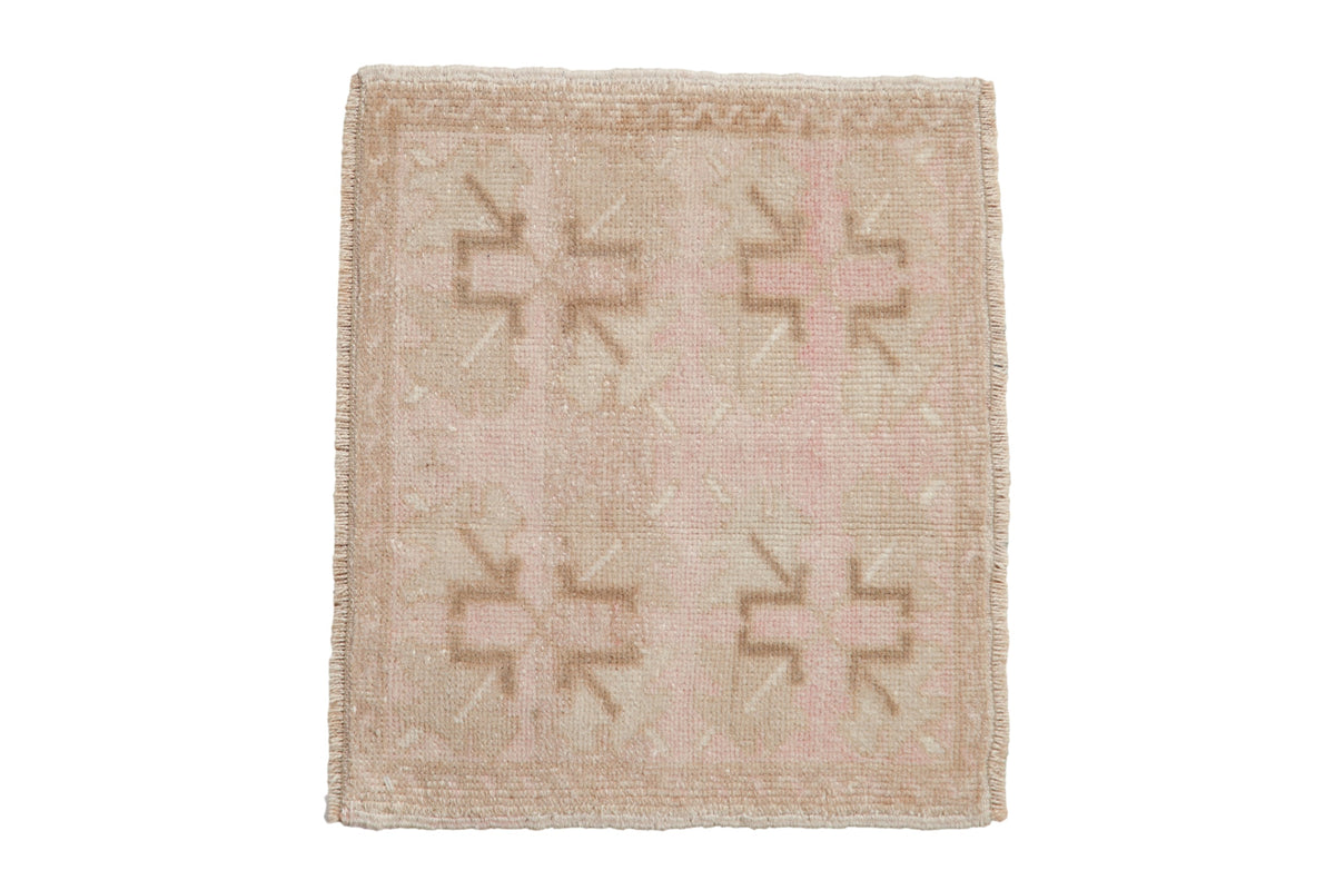 Vintage distressed Oushak square mat with a geometric pattern in soft dusty rose and sand tones.