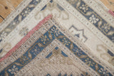 A folded corner on the distressed Oushak rug reveals the woven back and machine-bound edge.