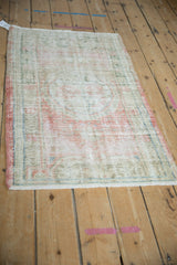 Distressed vintage Oushak rug seen from an angle, highlighting its time-softened texture and muted colors.
