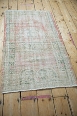 Side view of a vintage distressed Oushak rug, highlighting its time-softened pile and colors.