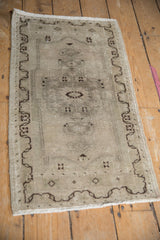 Distressed Oushak rug's abrashed field, dark brown meandering border, and patinaed wool tips.