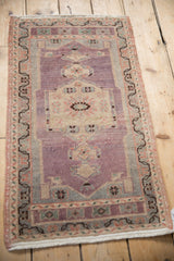 Close-up of vintage Oushak rug's distressed aubergine abrashed field with antique ivory medallion details.