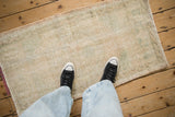 Distressed Vintage Oushak rug, faded cream and pale green, with worn pile showing foundation.