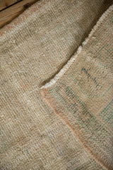 Distressed vintage Oushak rug showing exposed foundation and painted reverse marks.