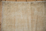 Distressed vintage Oushak rug texture with worn pile, exposed foundation, and neutral tones.