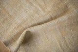 Cream and beige texture of distressed vintage Oushak rug, with foundation showing.