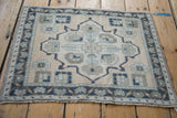Textured vintage distressed Oushak rug close-up, featuring the dusty navy meandering vine border.