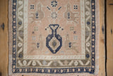 Evenly worn texture on a vintage Oushak mat, highlighting the central potted plant design.