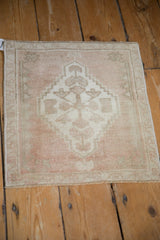 Detailed view of distressed Oushak rug with stepped medallion, floral fills, and thin border.
