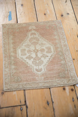 Distressed Oushak corner with pale dusty rose field and antique ivory floral vine border.