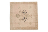 Distressed vintage Oushak square mat with a central floral design in sand, dusty rose, and soft navy.