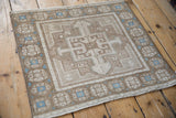 Full design of a distressed Oushak mat in earthy brown and beige with geometric sky blue accents.