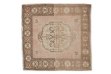 Vintage distressed Oushak square rug featuring a scalloped center medallion in beige, sand, and pale coffee brown tones.
