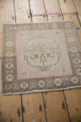 High-angle view of a square vintage Oushak rug showing its evenly worn, neutral-toned pile.