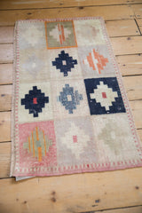 Distressed Oushak rug texture with navy blue stepped diamond motifs on ivory.
