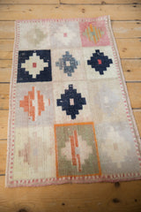 Dusty rose side selvage and distressed geometric panels on vintage Oushak rug.