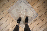 Hand-knotted distressed Turkish Oushak square mat with quatrefoil blossoms, muted beige and blush.
