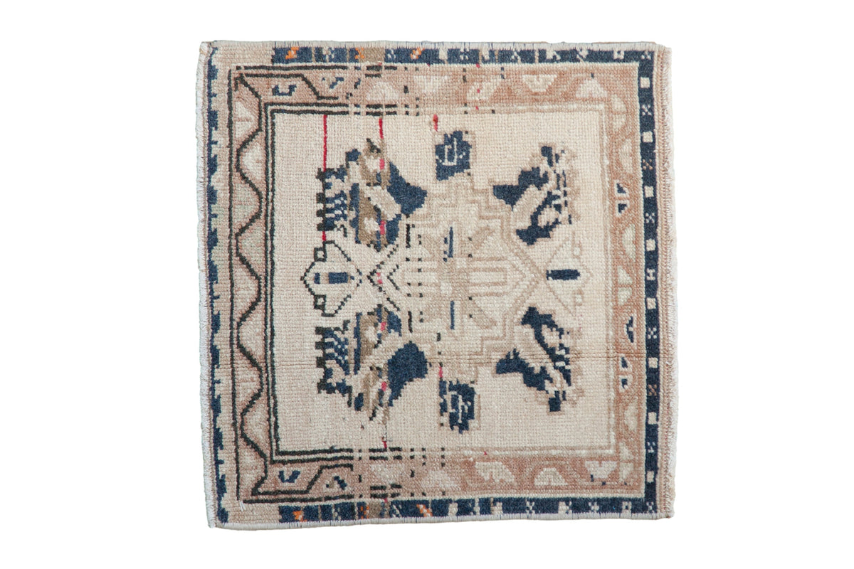 Vintage Oushak square rug with a distressed, geometric navy and ivory medallion on a cream field.