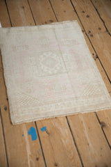 Distressed Oushak rug texture: ivory and faint pink abrashes, even wear, intact selvage.