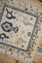 Distressed vintage Oushak rug pile with navy meandering vine border and ivory field.