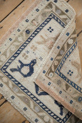 Distressed pile texture and navy meandering vine border on a vintage Oushak rug.