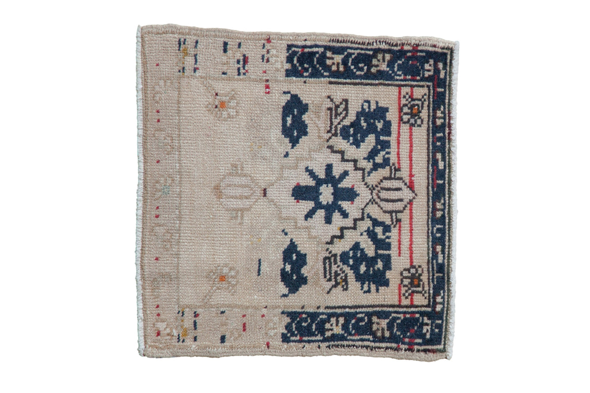 Vintage distressed Oushak square rug with a navy stepped medallion and floral blossoms on a beige field.