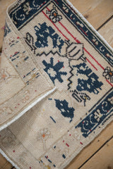 Folded corner of a vintage Turkish Oushak mat showing the hand-knotted pile and foundation.