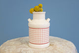 Vintage milk jug vase showing the reverse side with a red and white grid pattern.
