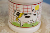 Close-up of the charming cow and sun illustration on the vintage ceramic milk jug.