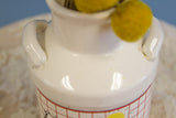 Glossy ceramic mouth and small arched handles of the vintage milk jug vase.