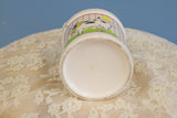 The clean, circular white ceramic base of the vintage milk jug vase.