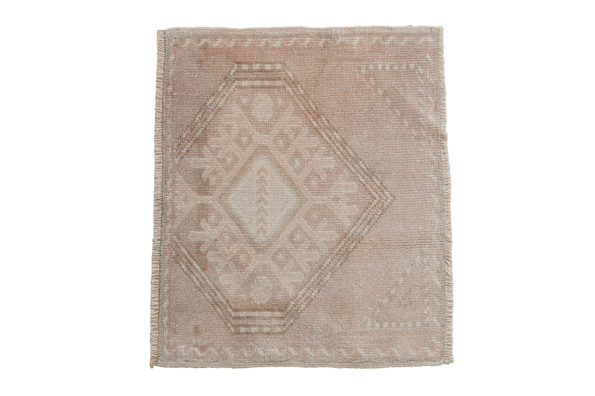 A vintage distressed Oushak square rug with a geometric gul medallion in neutral beige and ivory tones.