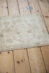Distressed vintage Oushak rug texture with soft, even wear on faded ivory and beige.