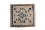 Vintage distressed Oushak square rug with a central medallion and navy wave border on a beige field.
