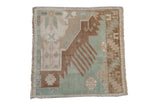 Distressed Oushak square rug: seafoam green, dusty bronze, ivory geometric finned patterns.