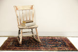 Vintage Persian Sarouk rug with deep royal blue field, rosy red borders, and storied floral patterns.
