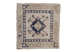 Distressed vintage Oushak square rug showing even wear, with a navy geometric medallion on an ivory field.