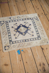 Angled perspective on a vintage distressed Oushak rug showing its low, evenly worn pile.