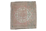 A distressed vintage Oushak square rug with a scalloped medallion in soft pink, sand, and aqua green.