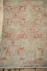 Distressed texture of vintage Oushak rug with faded blush floral blossoms.