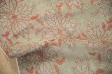 Faded blush floral motifs on a textured beige distressed vintage Oushak rug pile.