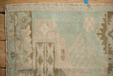 Corner of a vintage Turkish Oushak rug showing the machine-bound edge and evenly worn pile.