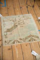 Vintage Oushak mat showing its even wear and geometric sampler design in muted green and ivory tones.