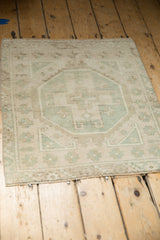 Textured distressed pile of a platinum and mint Oushak rug with bound edge.
