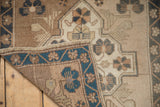 Corner folded back to show the hand-knotted weave and secured side selvage of the vintage Oushak rug.