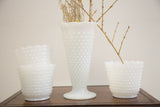 Set of four vintage white hobnail milk glass vases with ruffled rims.