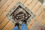 Vintage Oushak square mat with chocolate brown and beige scrolled leaves, shown to scale.