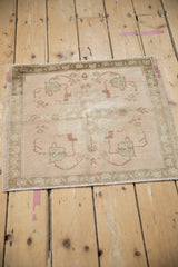 Distressed vintage Oushak rug mat with dusty rose field and sea foam green motifs.